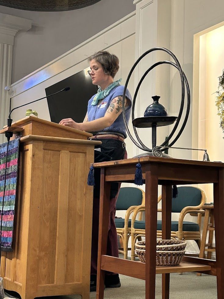 A speaker at a wooden lectern during a community gathering
