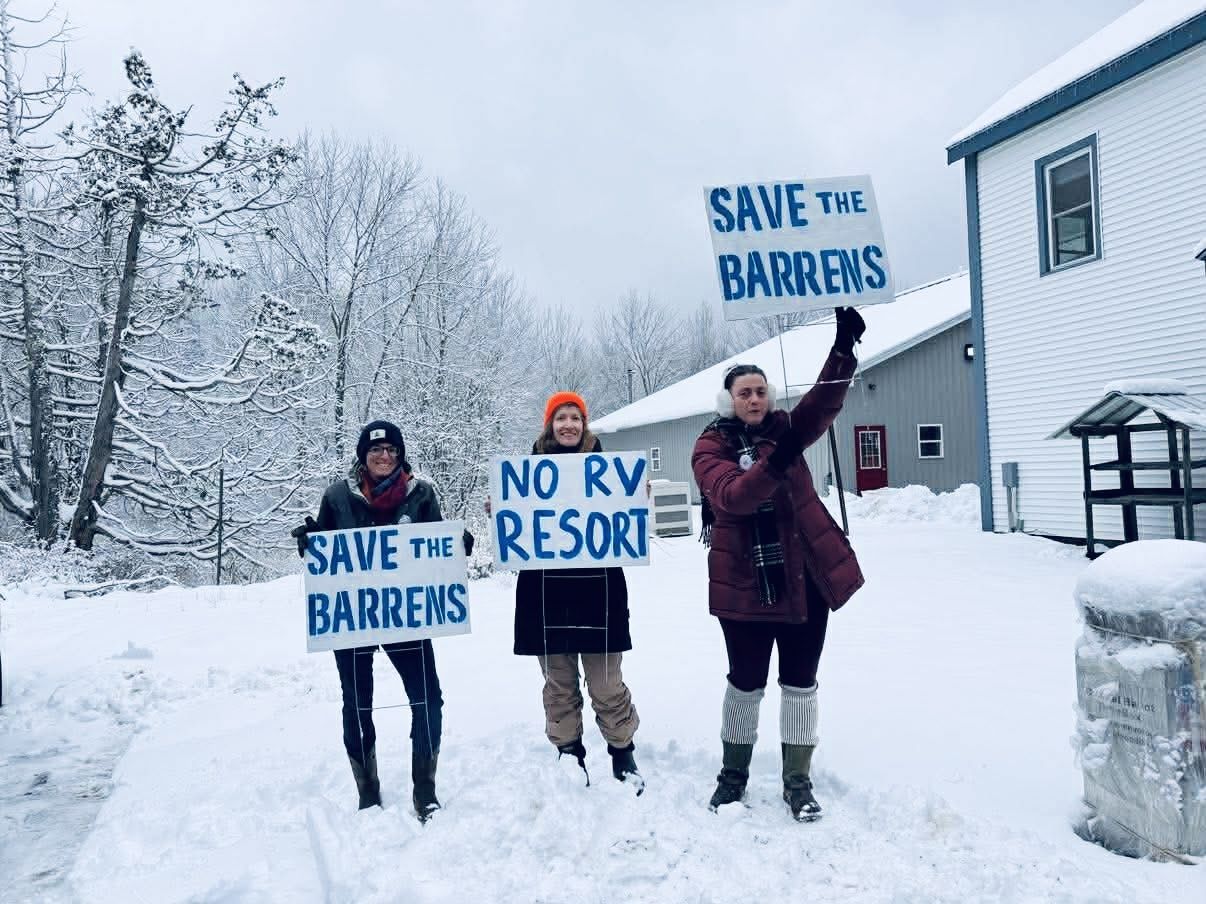 Community members holding Save the Barrens signs in the snow